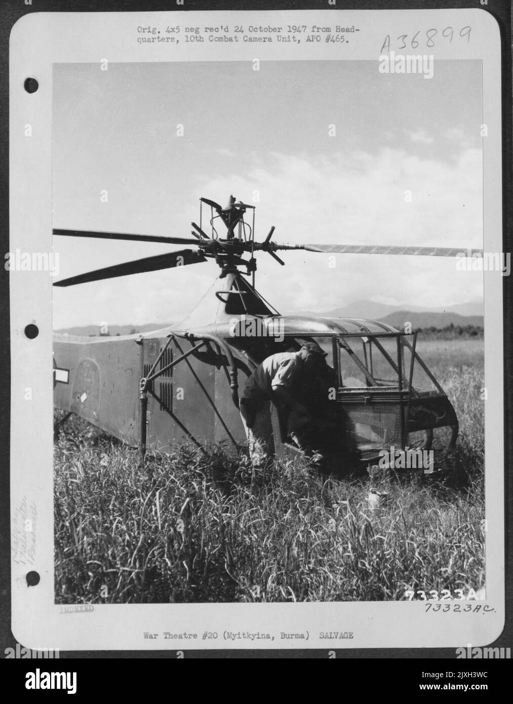 Sikorsky Yr-4 ['.. Whirlaway'] Helicopter Pilot LT. Irvin C. Steiner montiert seine Werkzeuge und Farben für die Rettung von Instrumenten und die Markierung der Flügel eines abgestürzten Flugzeugs in der Nähe von Myitkyina, Burma. Stockfoto