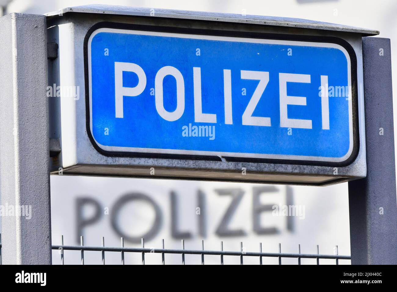 Ein blaues Schild mit der Aufschrift „Poizei“ für „Polizei“ auf einer