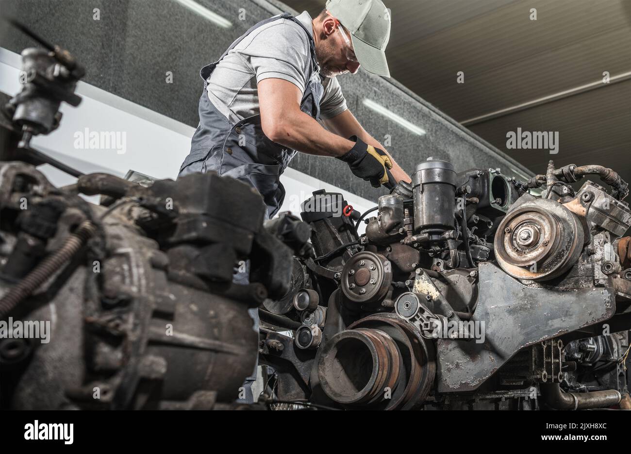 Kaukasische Professional Truck Mechanic Wiederaufbau Heavy Duty Truck Dieselmotor. Thema Automobilindustrie. Stockfoto