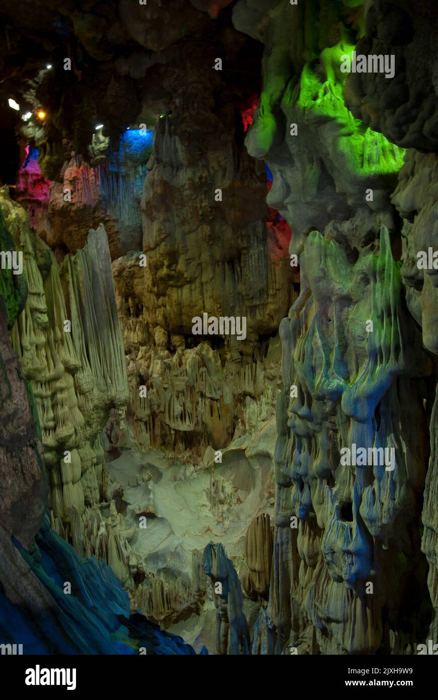 Stalaktitenhöhle, die von farbigen Scheinwerfern auf Hang Dau Go (Wooden Stake Island), einer der vielen Inseln der Halong Bay im Nordosten Vietnams, beleuchtet wird. Stockfoto