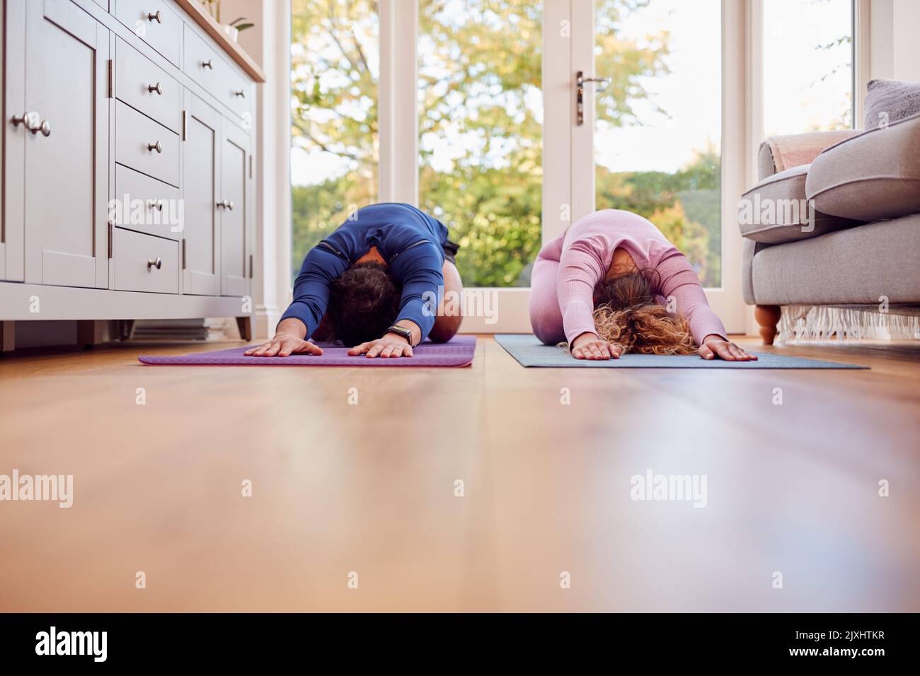 Paar Stretching Auf Matten Zu Hause Tun Yoga-Übungen Zusammen Stockfoto