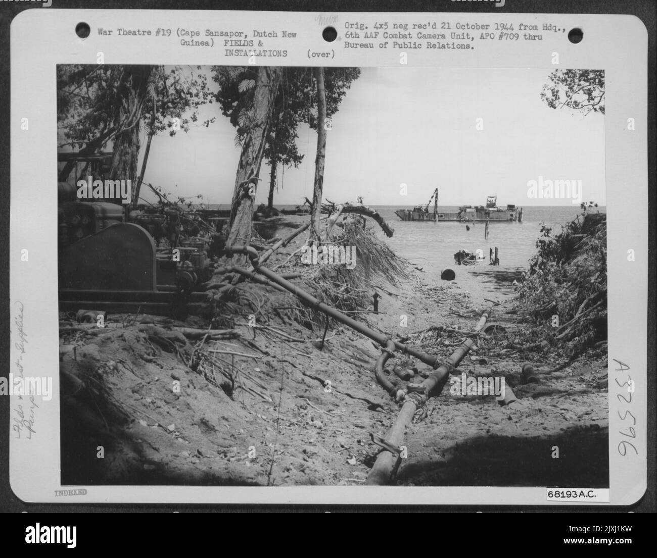 Als der Streifen Mar nahe Kap Sansapor auf dem holländischen Neuguinea-Festland der Fertigstellung näherte, wurden Benzinlager und andere zusätzliche Einrichtungen zum Betrieb eines Flugplatzes errichtet. Hier wird Benzin von einem Tanker, der vor dem Ufer liegt, zu gepumpt Stockfoto