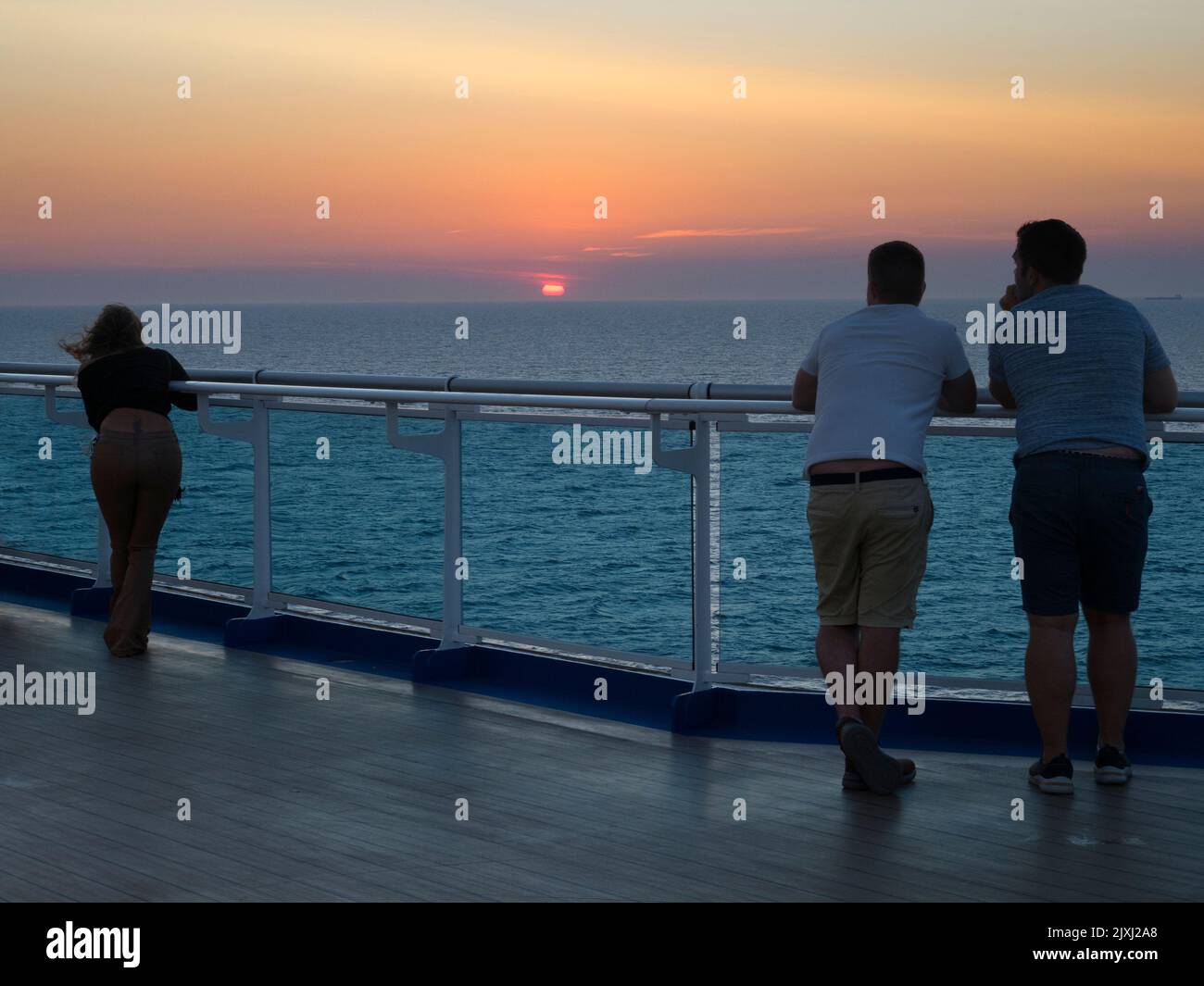 Ruhige Umgebung, Passagiere beobachten einen dramatischen Sonnenuntergang über der Nordsee. Wir sind an Bord eines Kreuzfahrtschiffes, das in Richtung des großen Hafens von Rotterdam in der geht Stockfoto