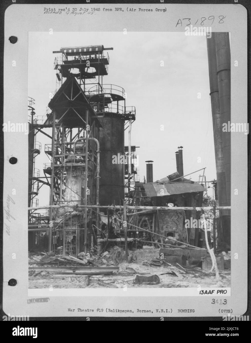 Hölzer, Rohre und Träger, einst die Eingeweide dieser riesigen Knackanlage bei Balikpapan, liegen in der Verwirrung der Strohhalme. Diese Raffinerie produzierte Benzin für die japanische Luftwaffe und Marine. „Jungle Air Force“-Bomber haben die Aufgabe des Abrisses in der erfüllt Stockfoto