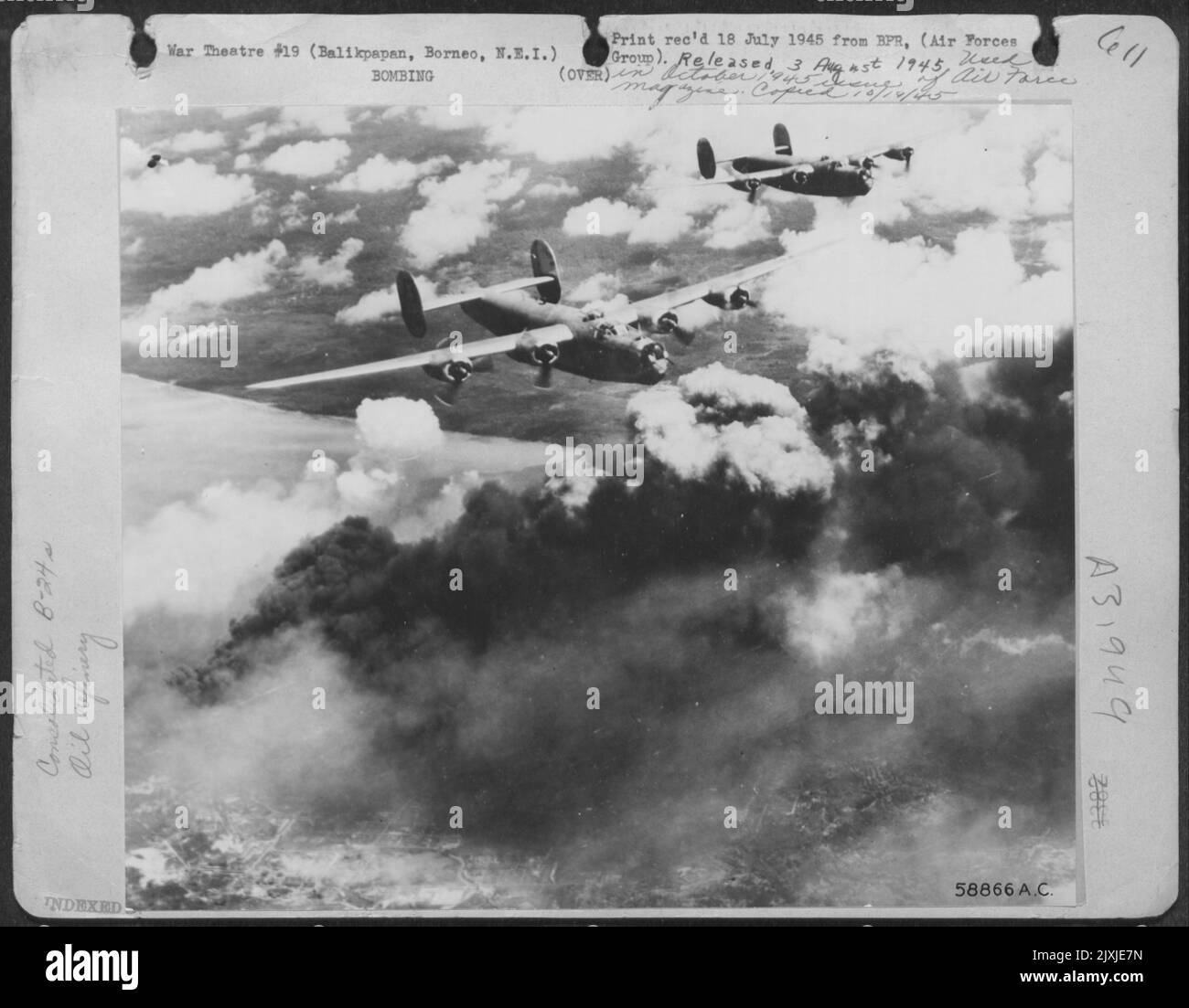 Diese 13. AAF Liberators fliegen zwei Meilen hoch über Balikpapan, Borneo, und pflügen durch Rauch, der durch Öltankfeuer verursacht wird, die von anderen Schweren in derselben Formation explodiert sind. Dies war einer der täglichen Streiks vor der Invasion gegen den großen japanischen Borneo Stockfoto