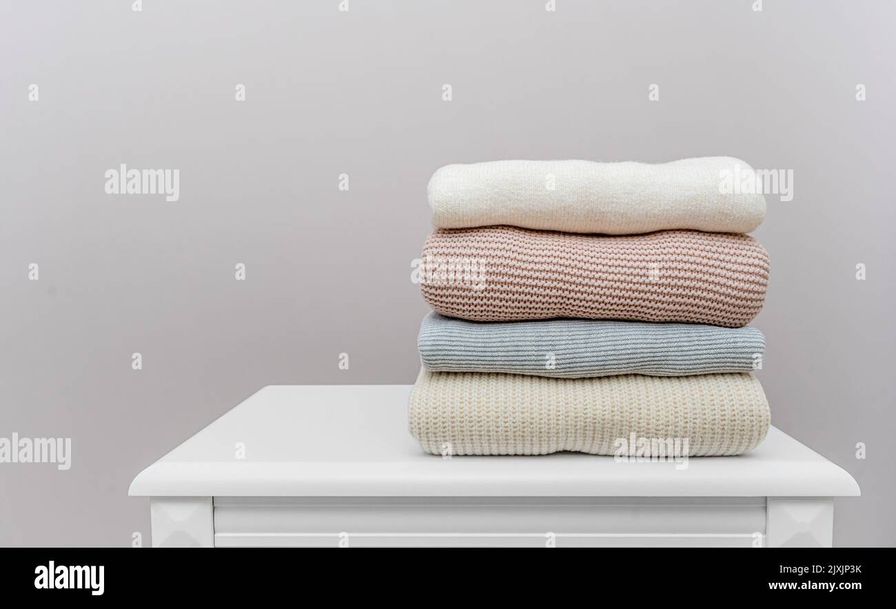 Warme Winterpullover stehen auf dem Nachttisch. Stockfoto
