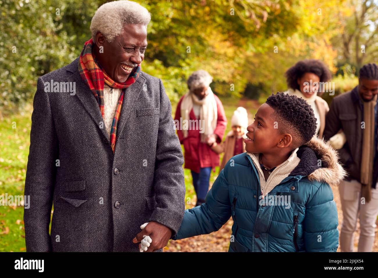 Lächelnde Familie Mit Mehreren Generationen Spaß Beim Gemeinsamen Spaziergang Durch Die Landschaft Des Herbstes Stockfoto