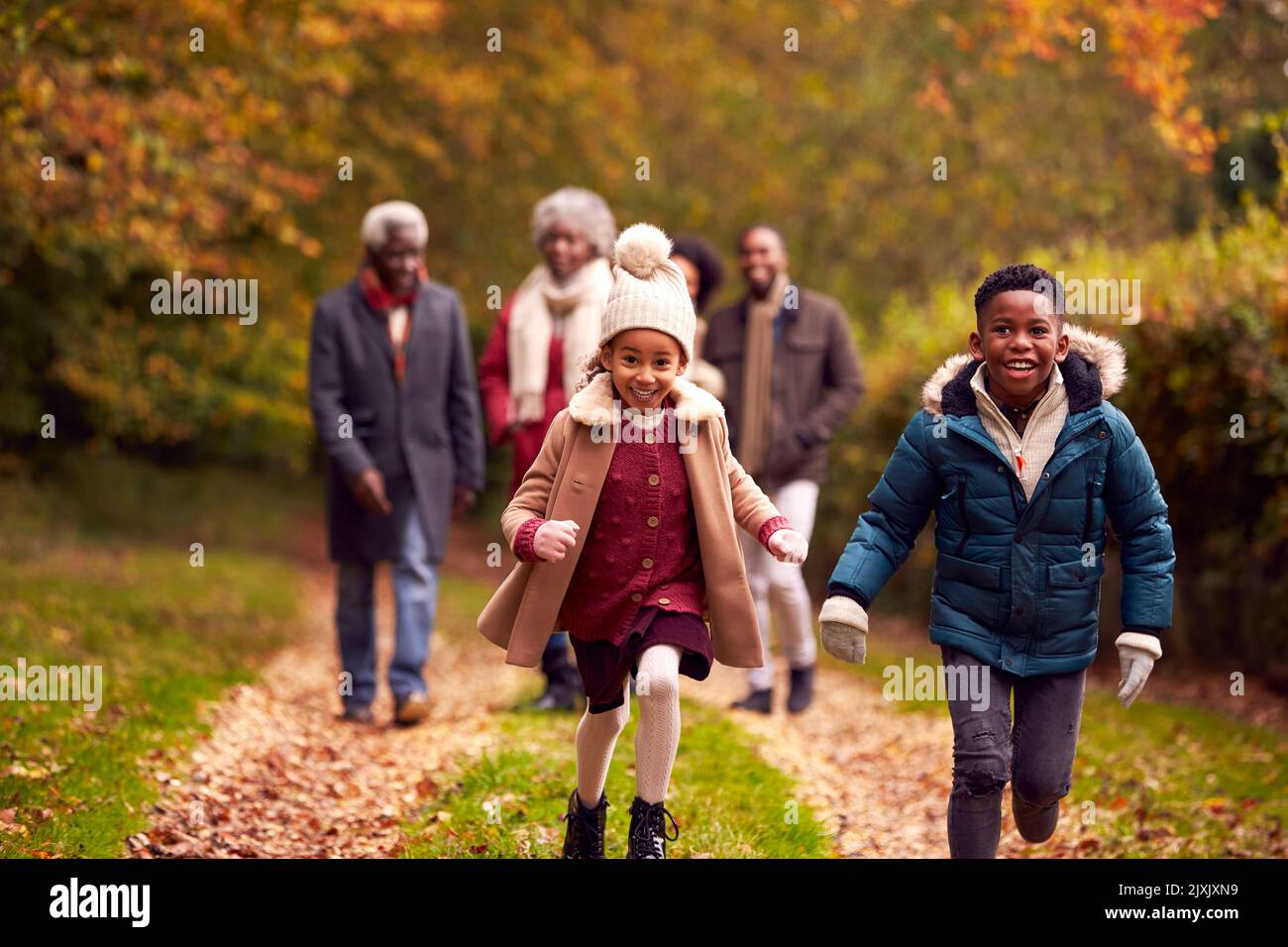 Lächelnde Familie Mit Mehreren Generationen Spaß Beim Gemeinsamen Spaziergang Durch Die Landschaft Des Herbstes Stockfoto