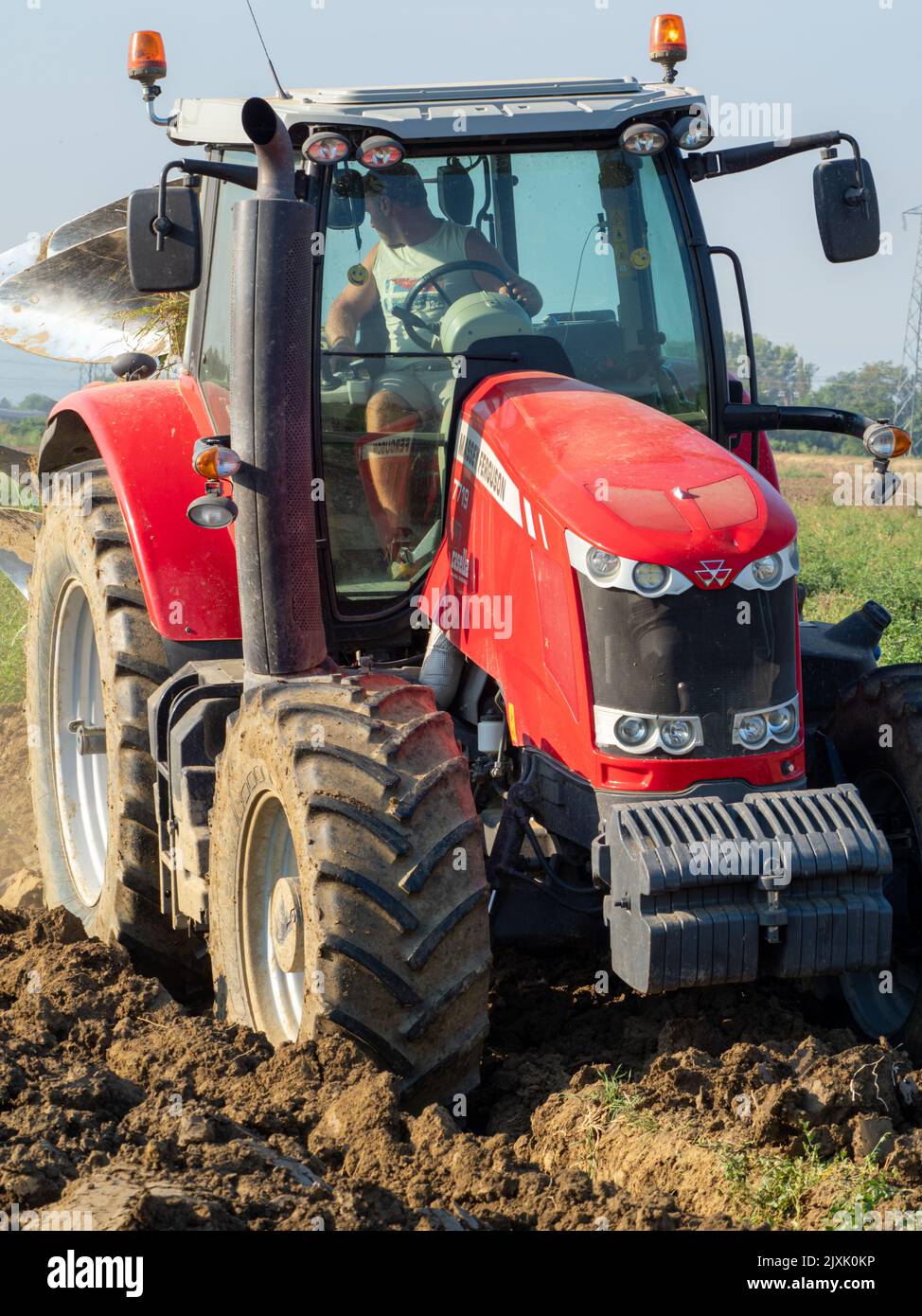 4K Video von rotem Traktor, der das Land auf dem Land pflügt. Stockfoto