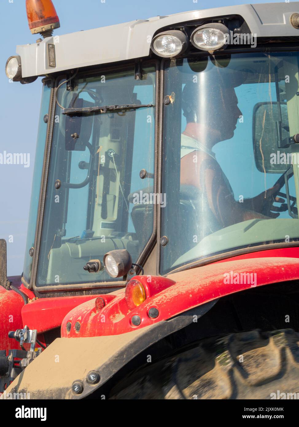 4K Video von rotem Traktor, der das Land auf dem Land pflügt. Stockfoto