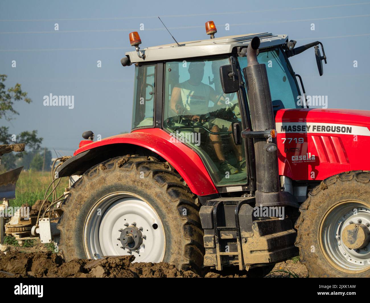 4K Video von rotem Traktor, der das Land auf dem Land pflügt. Stockfoto