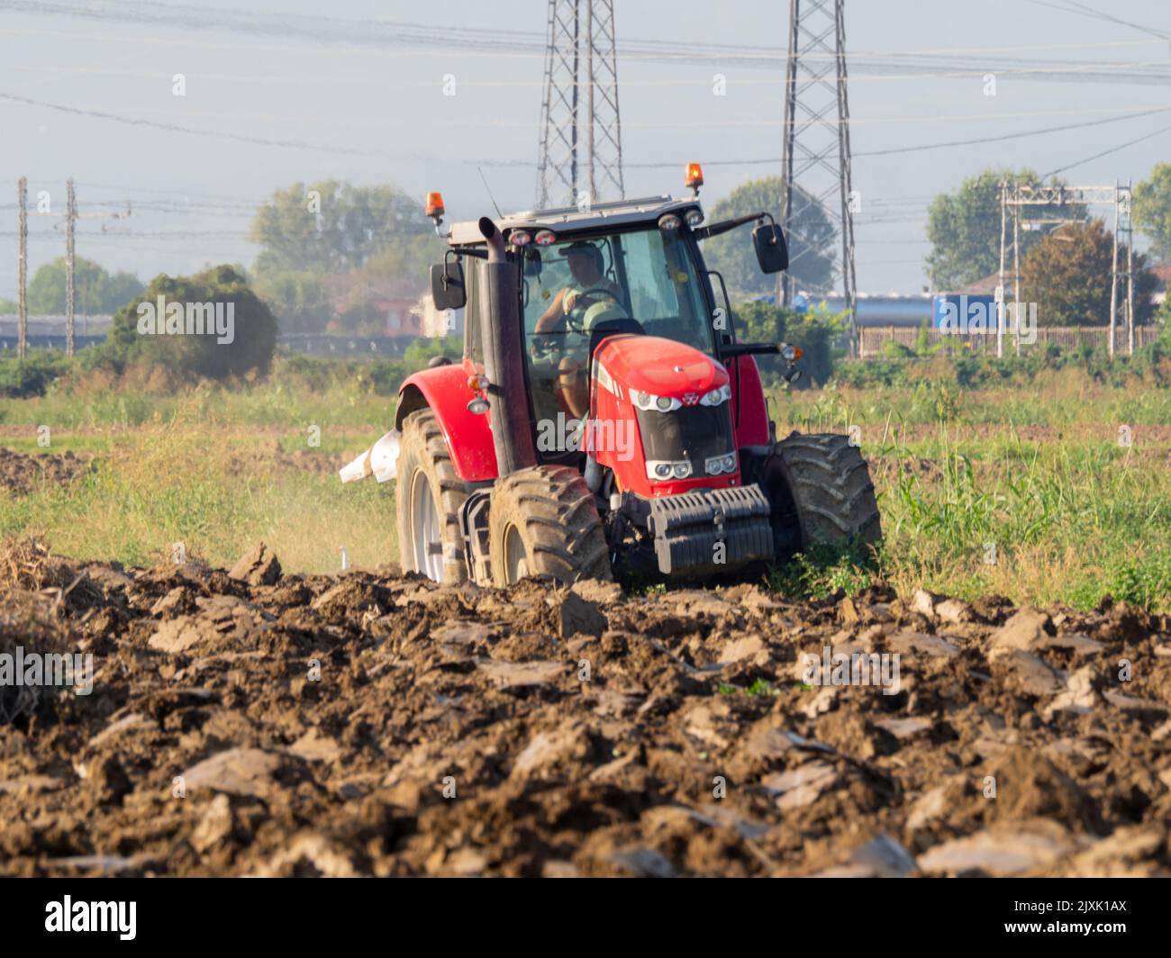 4K Video von rotem Traktor, der das Land auf dem Land pflügt. Stockfoto