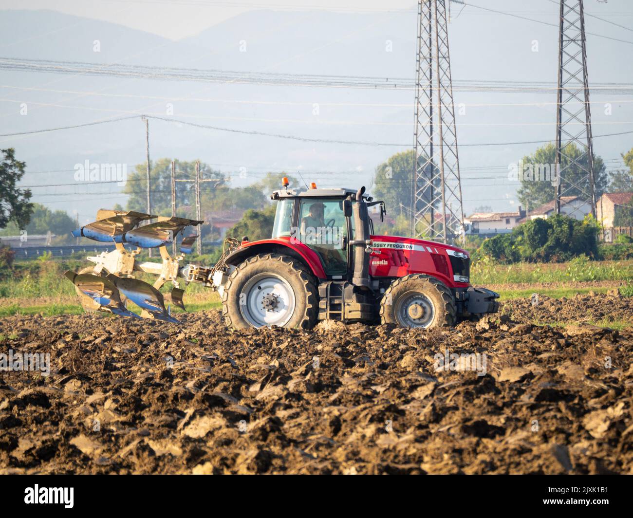 4K Video von rotem Traktor, der das Land auf dem Land pflügt. Stockfoto