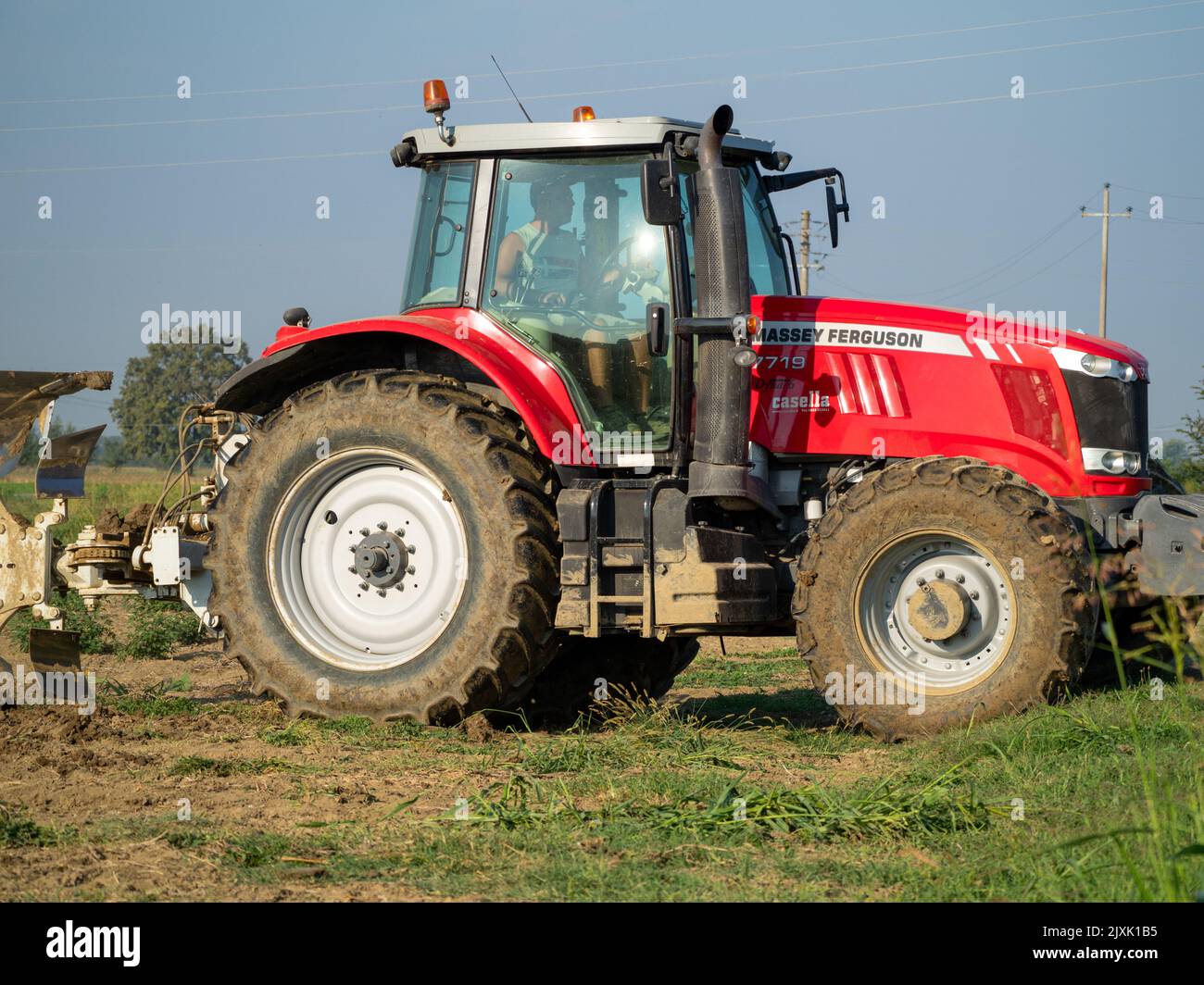 4K Video von rotem Traktor, der das Land auf dem Land pflügt. Stockfoto