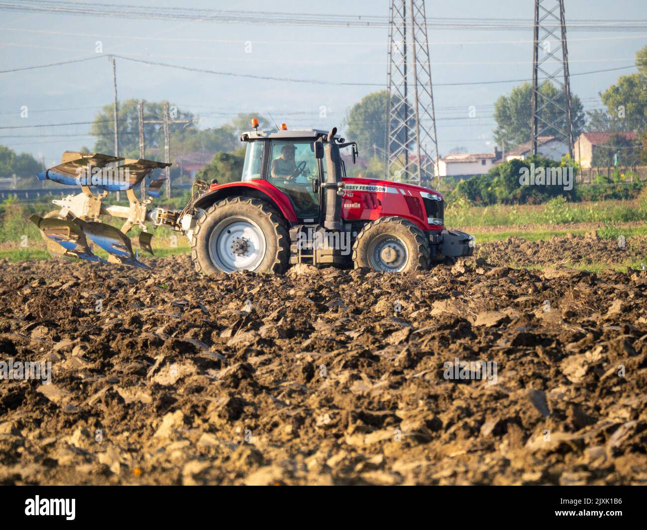 4K Video von rotem Traktor, der das Land auf dem Land pflügt. Stockfoto