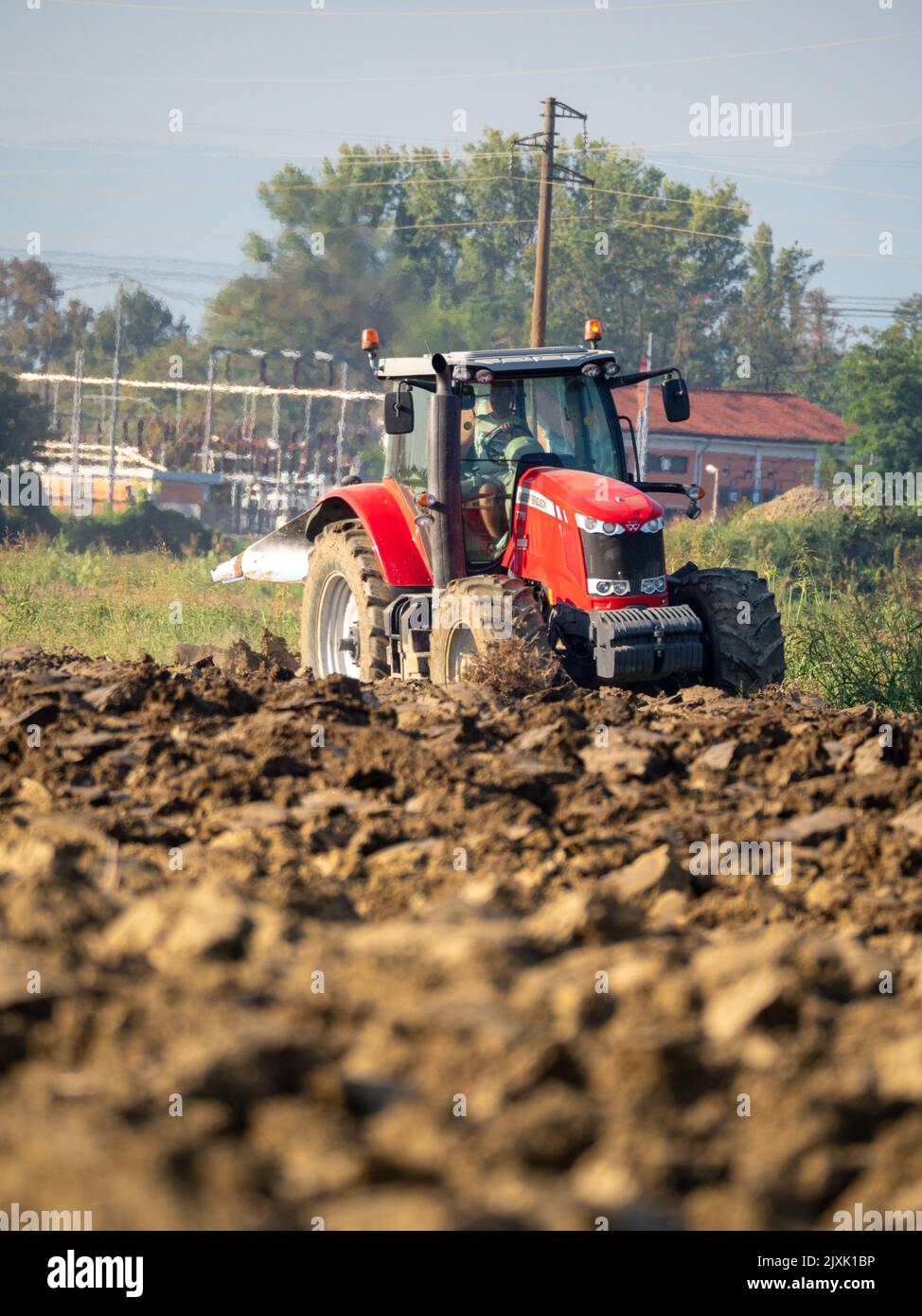 4K Video von rotem Traktor, der das Land auf dem Land pflügt. Stockfoto