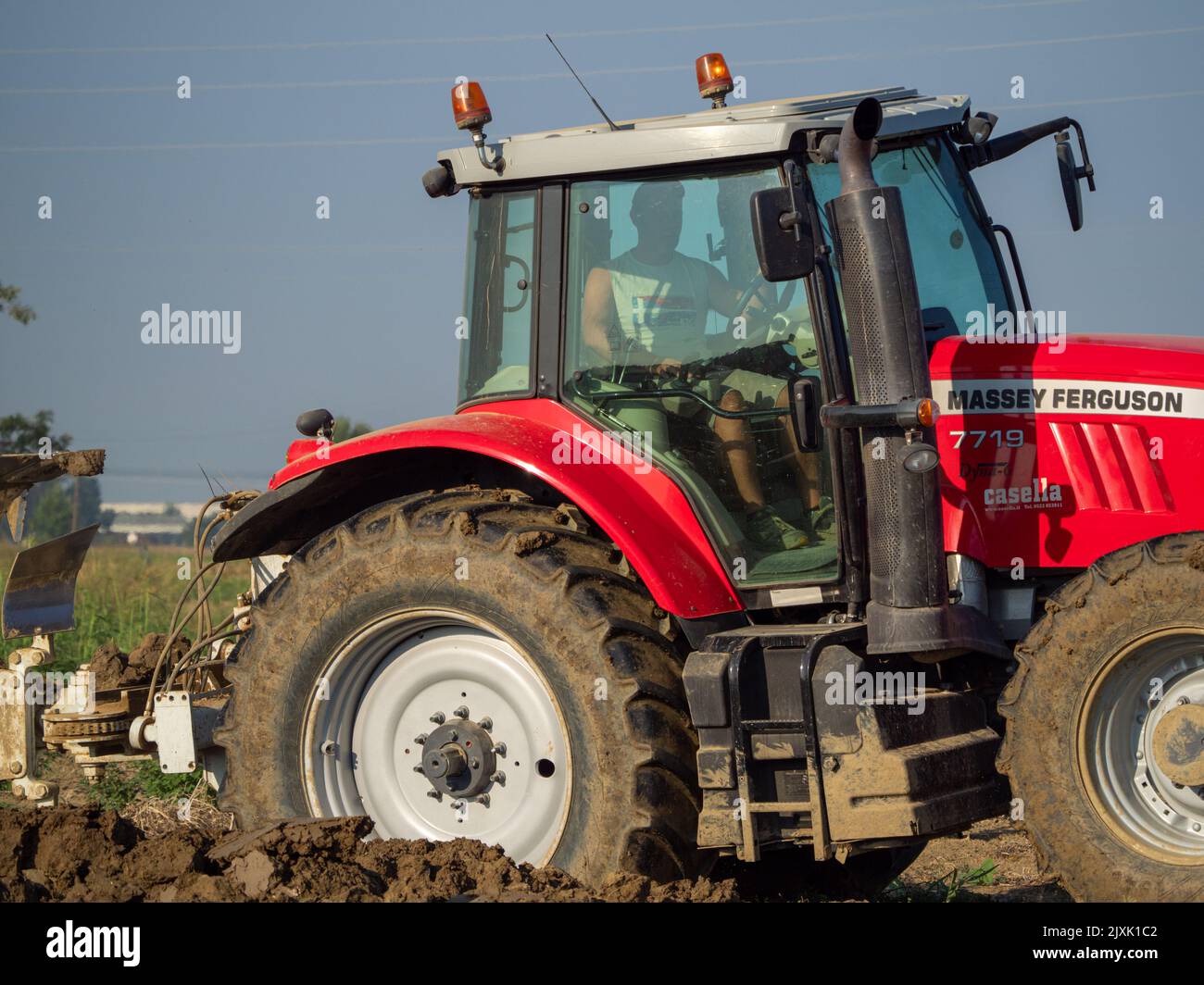 4K Video von rotem Traktor, der das Land auf dem Land pflügt. Stockfoto