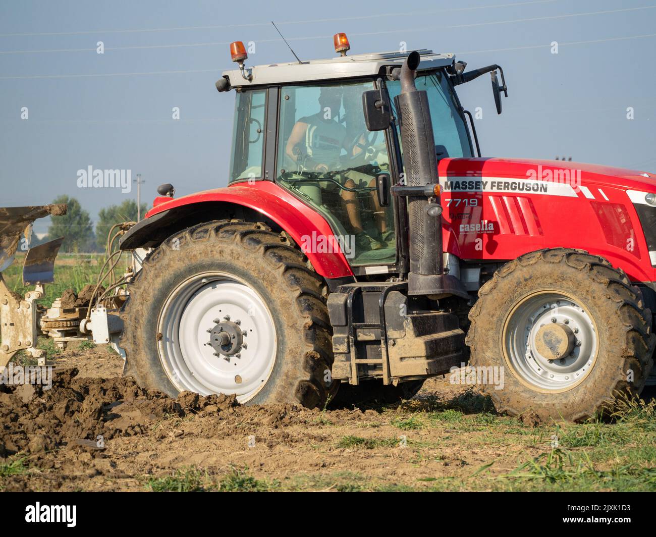 4K Video von rotem Traktor, der das Land auf dem Land pflügt. Stockfoto