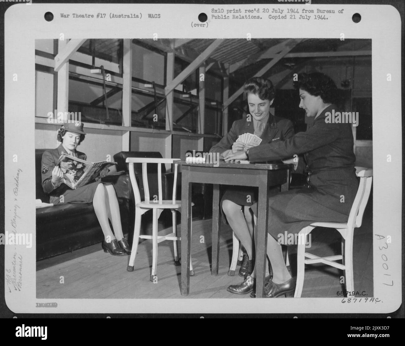 ENTSPANNUNG. ... Die Recreation Hall im WAC Camp irgendwo in Australien ist ein beliebter Ort zum Entspannen. Hier T/5 Florine Mathews von Corpus Christi, Texas, liest während Pvt. Woodie Johnson aus Littlefield, Texas und Pvt. Florenz Stockfoto