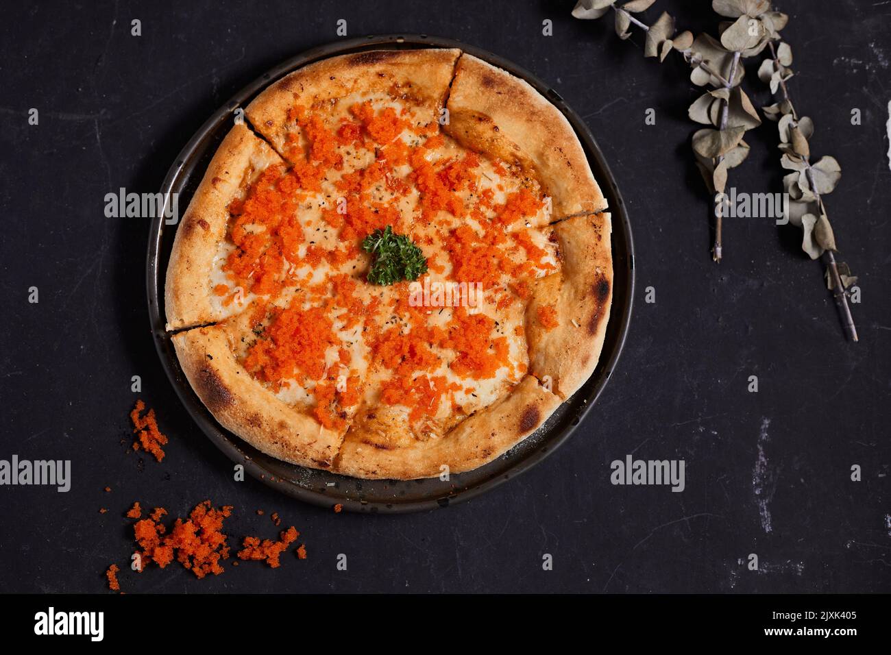 Hausgemachte Ebiko-Sahnesauce und Käse-Pizza auf dem Tisch. Stockfoto