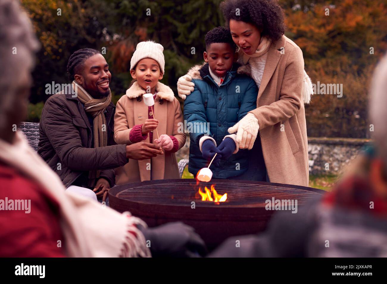 Multi-Generation-Familie Gemeinsam Im Herbstgarten Mit Viel Spaß An Der Toaste Von Sumpfarben Stockfoto
