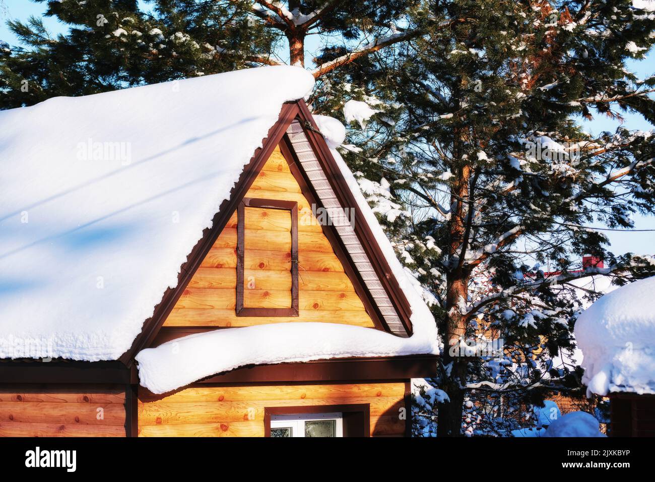 Haus in den alpen zwischen den Bäumen unter der großen Schneeverwehung von weißem Neuschnee. Landschaften und Hintergründe Stockfoto