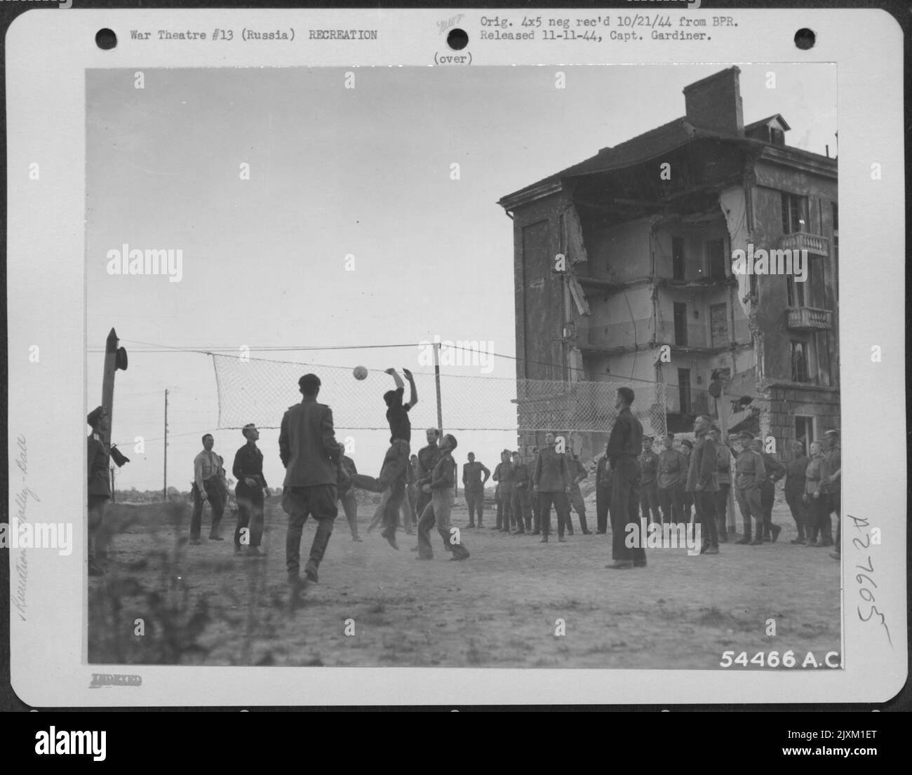 Amerikanische und russische gemischte Teams spielen jeden Abend Volleyball im Hauptquartier der US-strategischen Luftstreitkräfte des Eastern Command in Russland. Dahinter ist eine Probe des deutschen Abrisses. Stockfoto