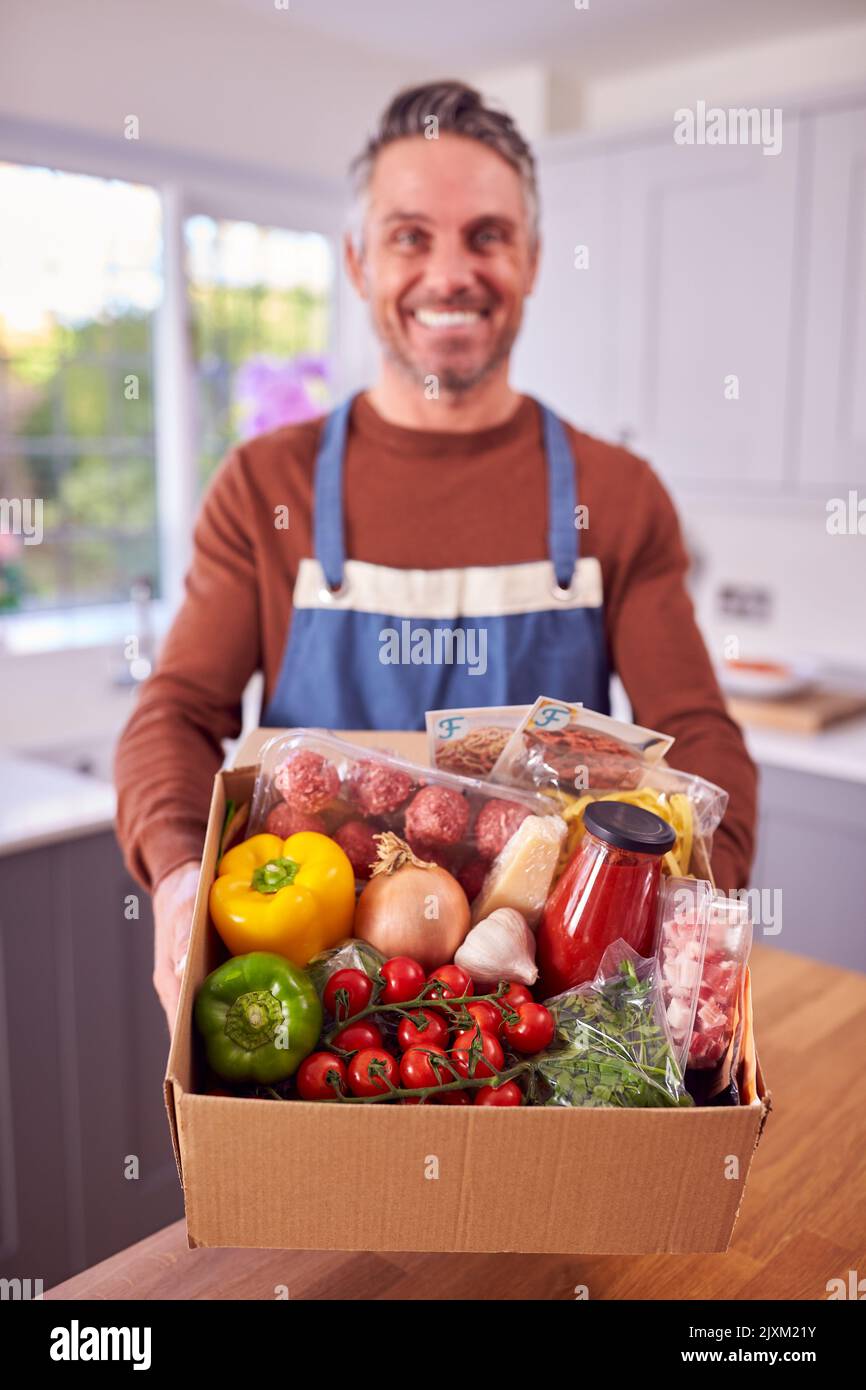 Portrait Of Mature Man Auspacken Online Mahlzeit Essen Rezept Kit Nach Hause Geliefert Stockfoto