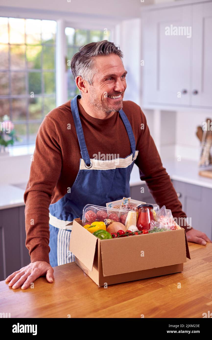 Portrait Of Mature Man Auspacken Online Mahlzeit Essen Rezept Kit Nach Hause Geliefert Stockfoto