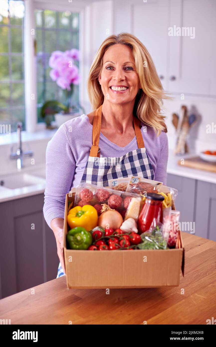 Portrait Of Reife Frau Auspacken Online Essen Rezept Kit Nach Hause Geliefert Stockfoto