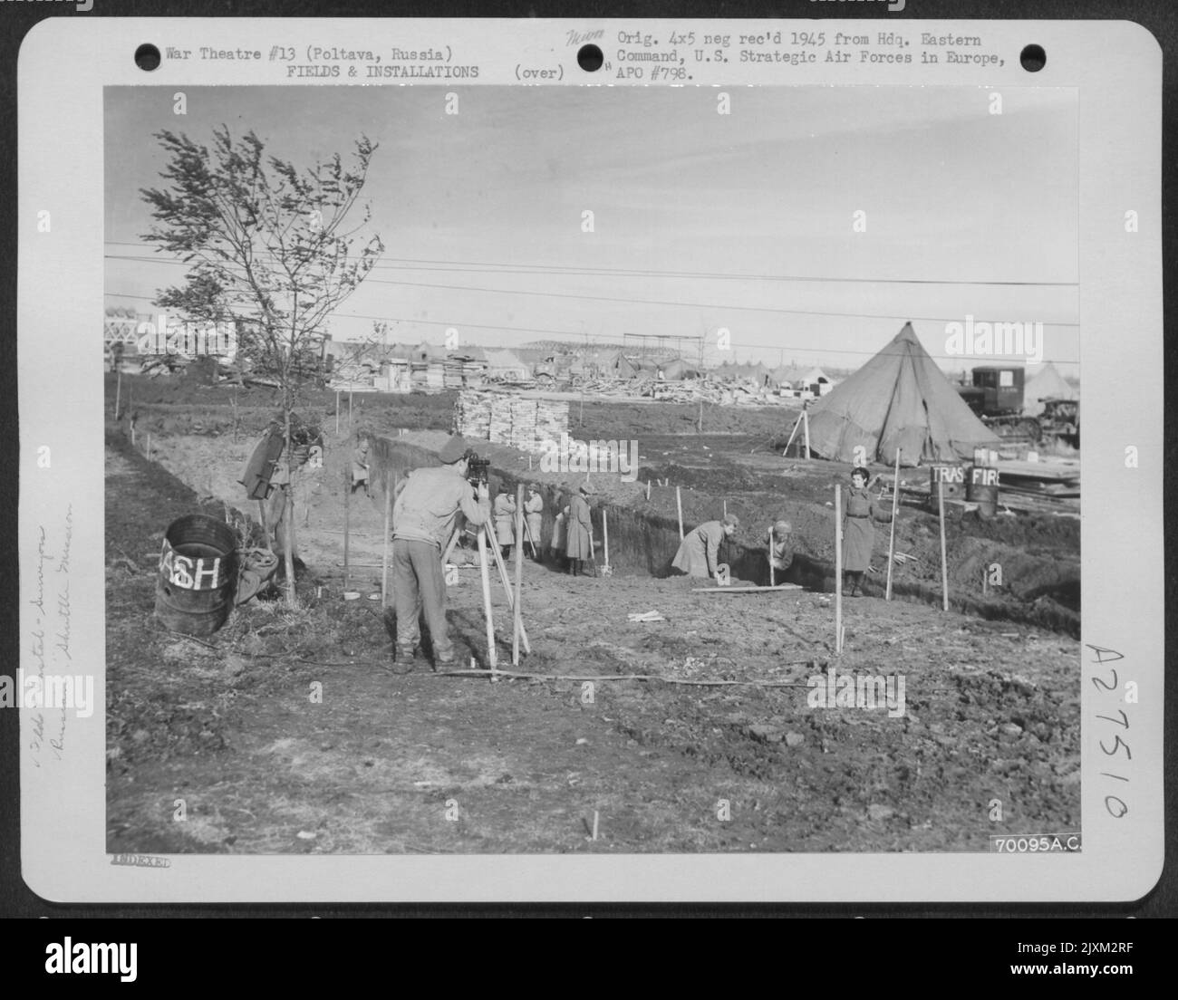 Ein "GI"-Vermesser, der mit einem russischen Mädchen arbeitet, markiert das Gebiet, in dem das gemeinsame amerikanisch-russische Theater auf dem Flugplatz Poltava, einer der Shuttle-Missionsstationen in Russland, errichtet werden soll. Die Bauarbeiten haben bereits begonnen. November 1944. Stockfoto
