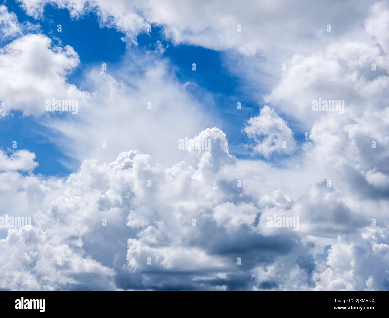 Oben weiße dramatische Wolken in einem blauen Himmel Stockfoto