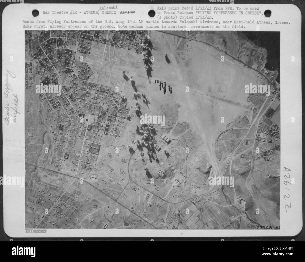 Bomben von den fliegenden Festungen der US-Armee 15. AF schleudern in Richtung Kalamaki Airdrome, in der Nähe des von den Nazis gehaltenen Athen, Griechenland. Einige Ausbrüche treten bereits auf dem Boden auf. Beachten Sie deutsche Flugzeuge in verstreuten Umbauten auf dem Feld. Stockfoto