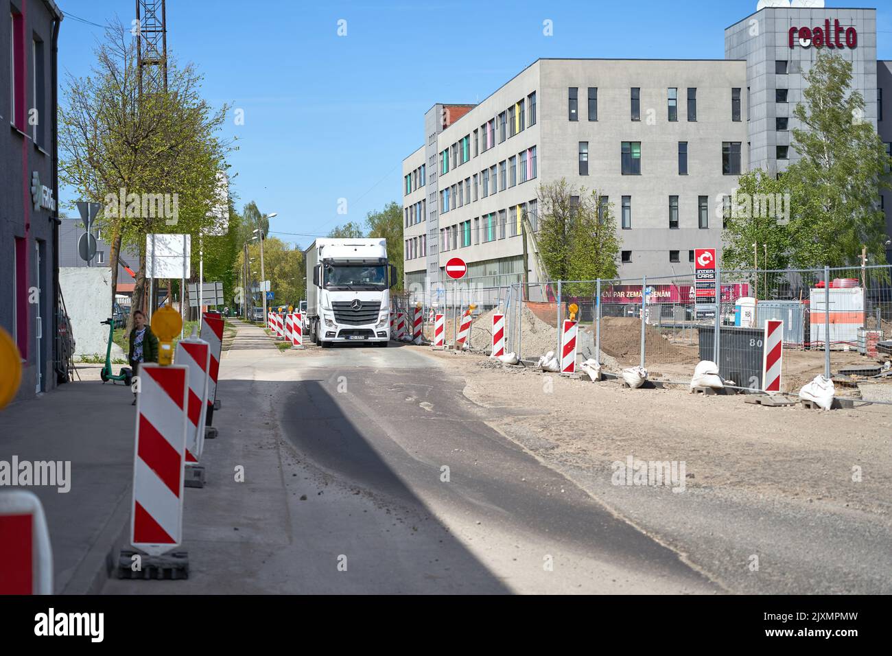 RIGA, LETTLAND - 13. MAI 2022: Weißer schwerer Lkw fährt auf der reparaturbedürftigen Straße Stockfoto