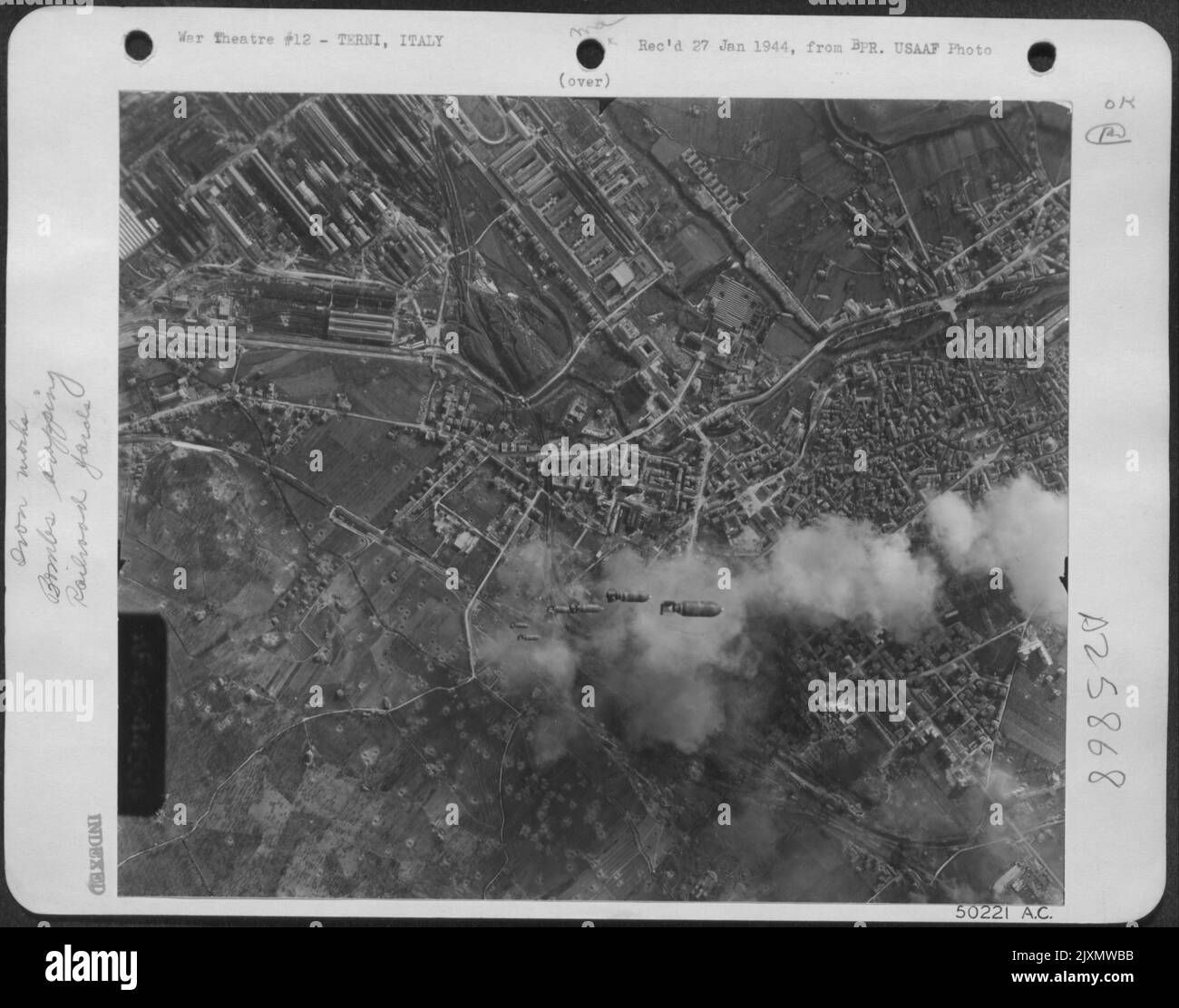 Sie fahren auf Rauch----- auf grauem Rauch von Bränden, die von früheren Sprengstoffen ausgelöst wurden, herabdriften, fallen sechs Bomben aus den Buchten des nordamerikanischen B-25 Mitchell-Bombers bei einem Angriff auf Terni, Mittelitalien, am 2. Januar.die Ziele, gut bedeckt, waren die Ziele der Stadt Stockfoto