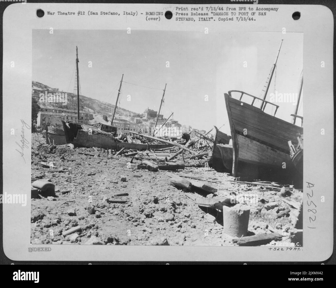 Zerstörte Schiffe, die durch Bomben von Flugzeugen der Mediterranean Allied Air Forces aus dem Wasser gesprengt wurden, sprengen den einst geschäftigen Hafen von San Stefano an der Westküste Mittelitaliens. Dieser Hafen, der einst dazu diente, Männer und Vorräte an die Nazis einzubringen, ist Stockfoto