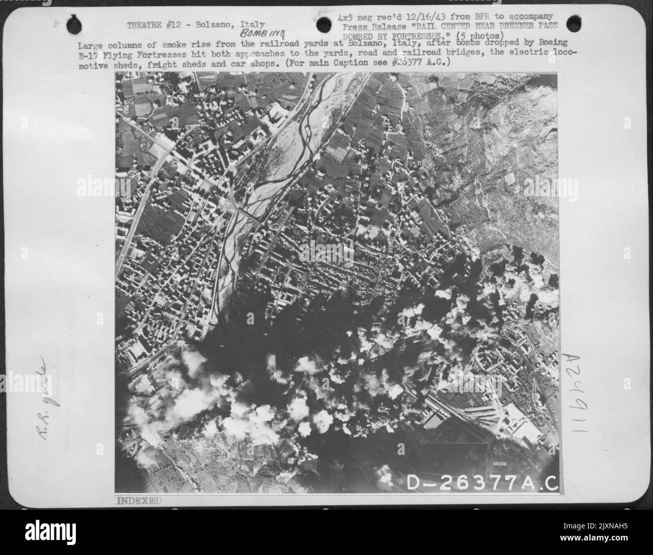 Große Rauchsäulen steigen von den Bahnhöfen in Bozen, Italien, auf, nachdem Bomben der Boeing B-17 Flying Fortresses die Zugänge zu den Werften, Straßen- und Eisenbahnbrücken, den Elektrolokomotiven-Schuppen, Güterschuppen und Autowerkstätten getroffen haben. Stockfoto