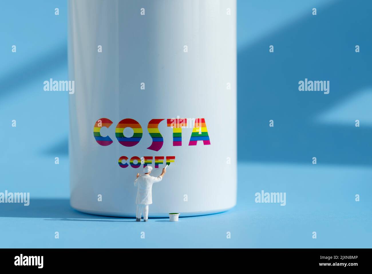 Auf der Seite einer Wasserflasche ist eine kleine Malerfigur abgebildet, die ein Costa-Logo zeigt. Das Branding ist in LGBTQ-Regenbogenfarben gehalten Stockfoto