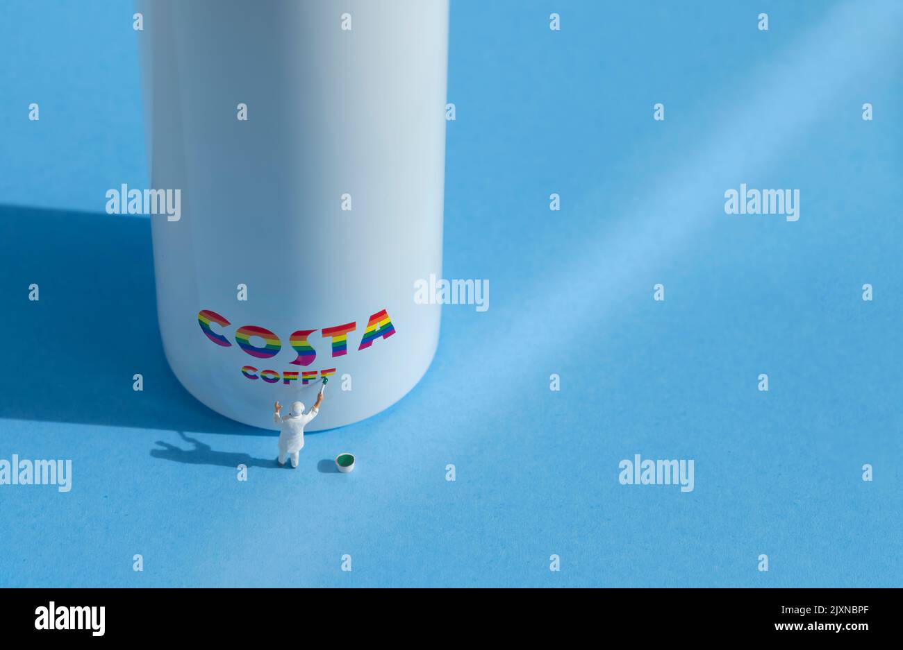 Auf der Seite einer Wasserflasche ist eine kleine Malerfigur abgebildet, die ein Costa-Logo zeigt. Das Branding ist in LGBTQ-Regenbogenfarben gehalten Stockfoto