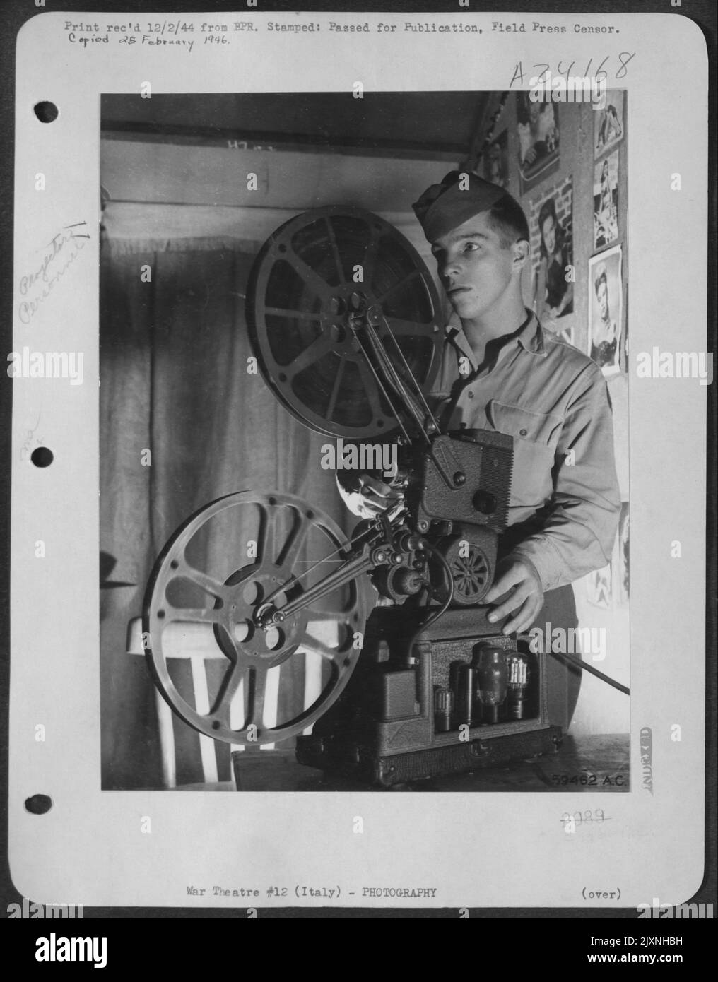Eine Menge Freude steht vor der Projektion auf die Leinwand von This Squadron'S Movie House von PFC. Frederich Nettell, Jr., Aus Detroit, Usa, Dank Der „Quick Service“-Richtlinie Für Den Film. Die G.I.S Sure Love 'EM. Stockfoto