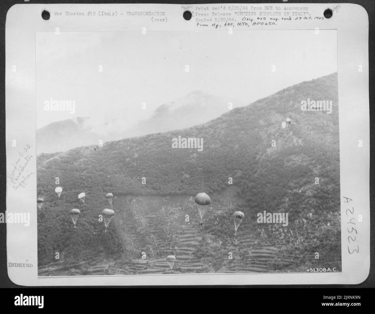 Alliierte Truppen, die in der gegenwärtigen Offensive durch den Berg Italiens vorrückten, kämpften manchmal so schnell voran, dass Maultierzüge mit Nahrung und Munitionsmittel das Tempo nicht halten konnten. Hier, in einer nebligen Schlucht, tragen kleine Fallschirme herunter Stockfoto