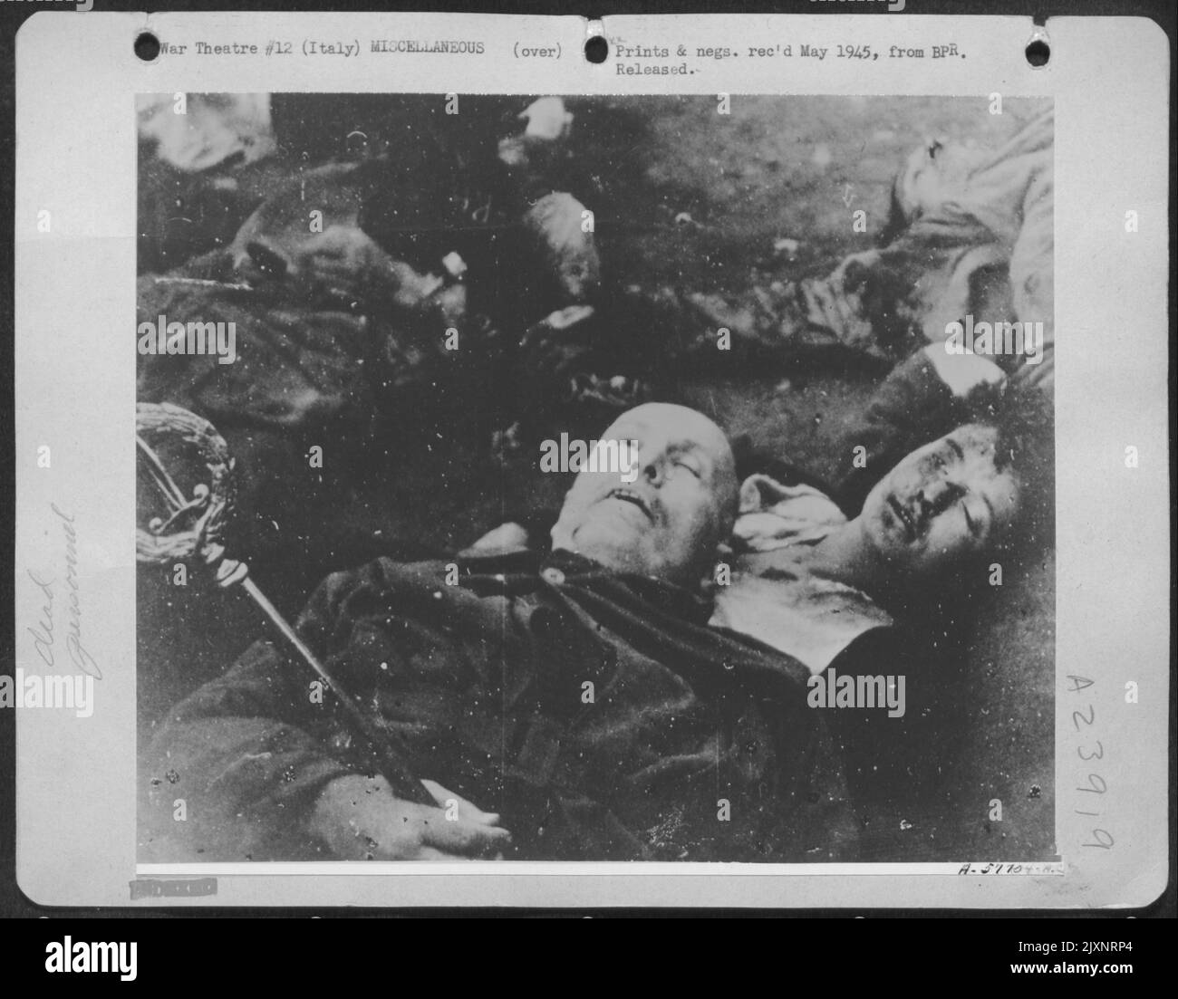 Mussolini Und Seine Neueste Herrin, Claretta Petacci, Nach Ihrer Hinrichtung Durch Italienische Patrioten In Mailand. Andere Hochrangige Faschisten Sind Um Sie Herum. Die Patrioten legten das römische Symbol der Diktatur in Mussolini's Hand. Er Und Seine Partei Wurden Gefangen Genommen Stockfoto