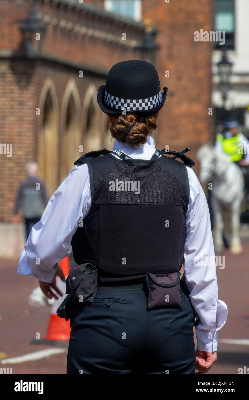 Weiblicher London bobby. Englische Polizistin von hinten in einer Straße in London, Großbritannien Stockfoto