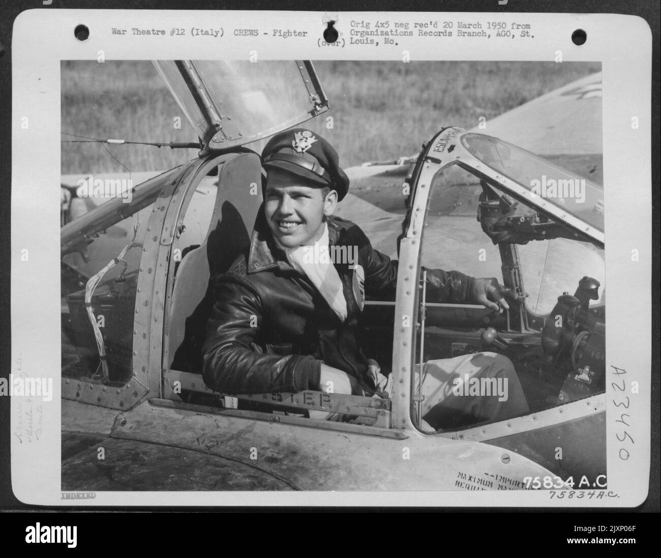 Ein Pilot der 94. Fighter Squadron, 1. Fighter Group, sitzt im Cockpit seiner Lockheed P-38 Lightning auf einem Luftwaffenstützpunkt irgendwo in Italien. Stockfoto
