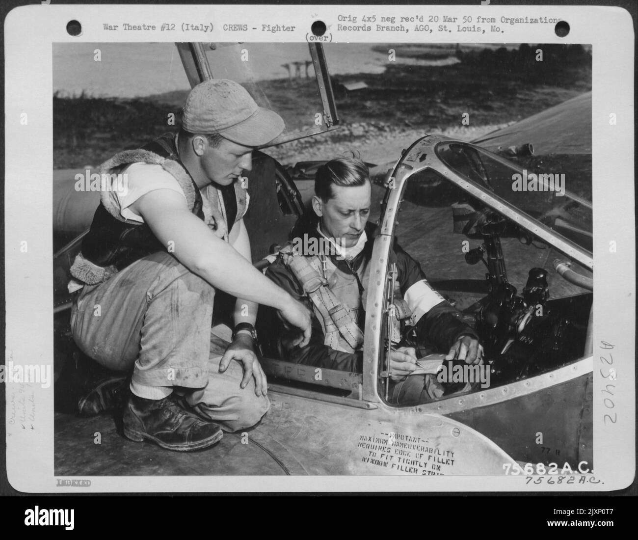 Bevor er auf Einen Missionspiloten der 94. FS aufgeht, macht 1. FG Einen Last Minute Check mit seinem Crew-Chef auf einem Flugplatz irgendwo in Italien. Stockfoto