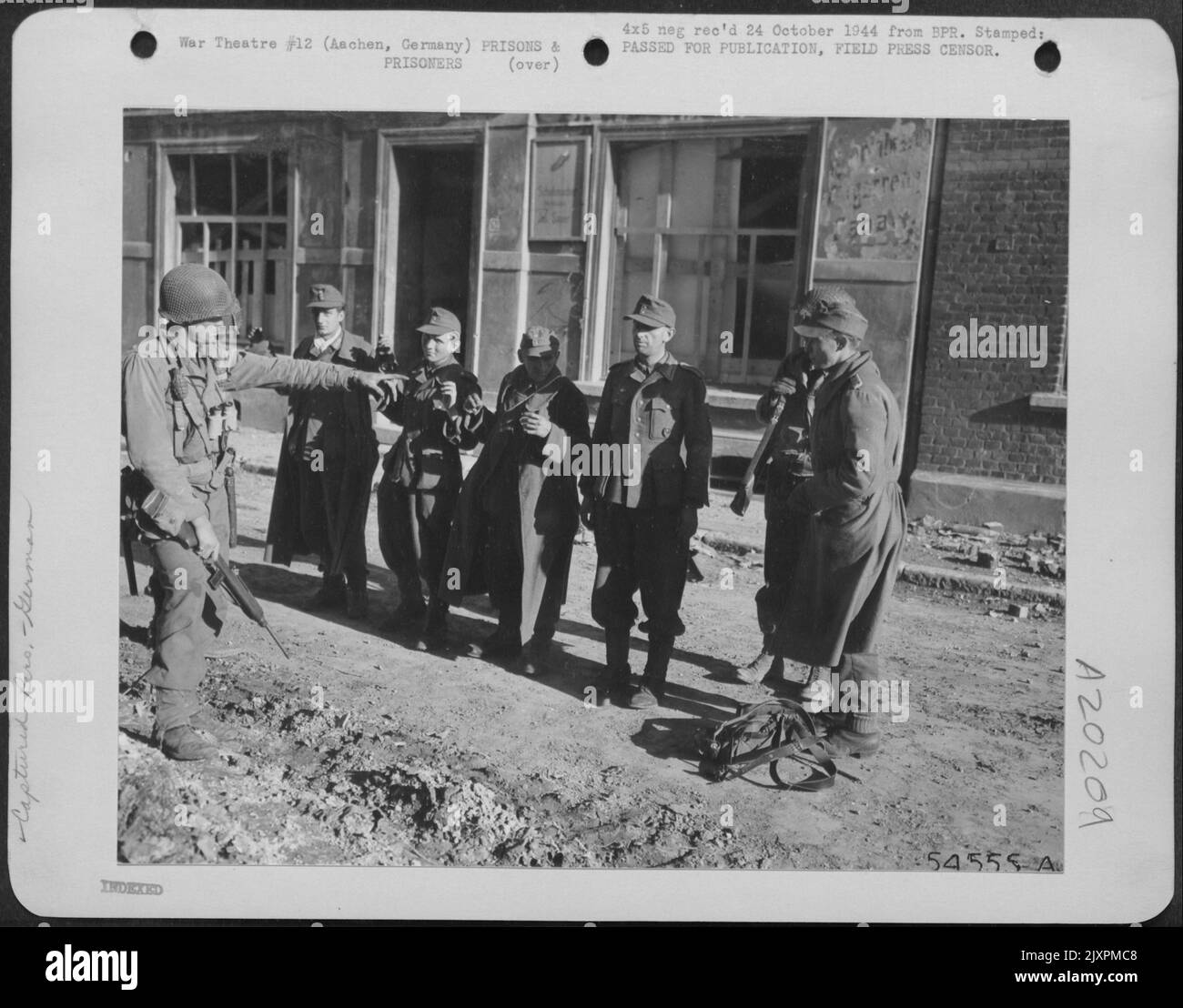 Einige der ersten deutschen Soldaten, die in Aachen gefangen genommen wurden, stehen unter dem Kommando eines amerikanischen Soldaten. Die Gefangenen wurden während eines Bombardements der Stadt durch Artillerie und Tauchbomber der Neunten Luftwaffe gefangen genommen. Stockfoto