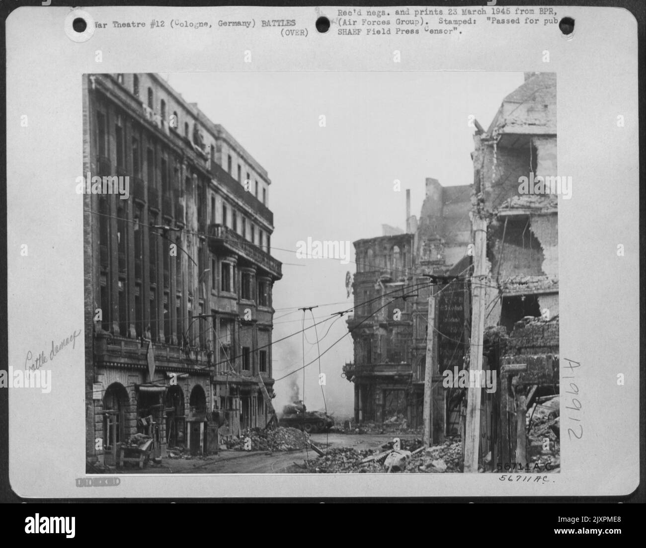 Ein deutscher Mark V-Panzer, der durch direkte Einschläge von Tankern der Dritten Armee abgefeuert wurde, brennt an einer Straßenkreuzung in Köln. Der gepanzerte Infanterist unter dem Kommando von Oberstleutnant William R. Orr, Albuquerque, N.M., erzielte drei direkte Treffer auf den gegnerischen Panzer. Stockfoto