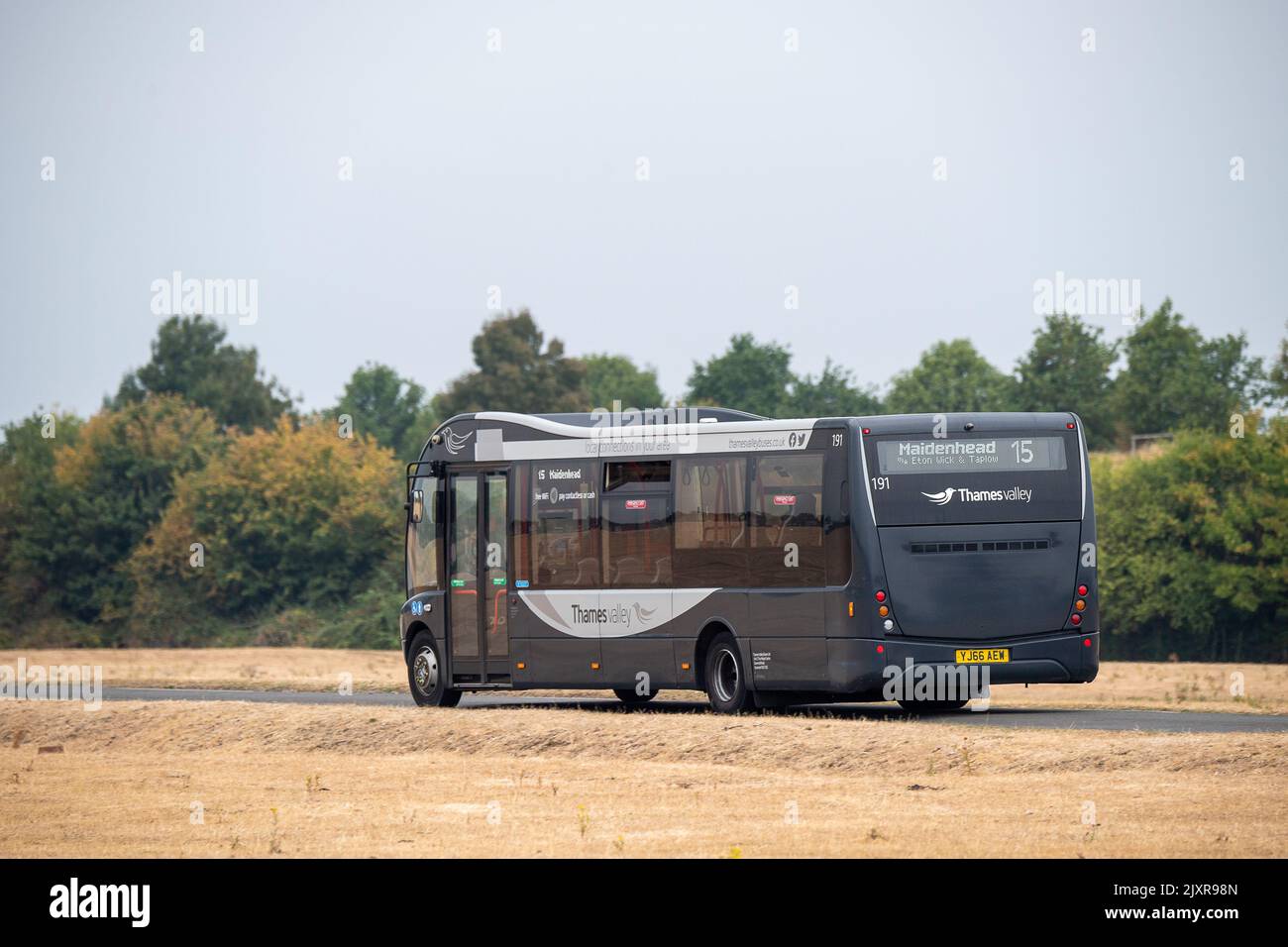 Dorney, Buckinghamshire, Großbritannien. 16.. August 2022. Ein Bus vom Thames Valley nach Maidenhead fährt durch die vertrocknende Landschaft des Dorney Common in Buckinghamshire. Nach den beiden Hitzewellen und Wochen ohne Regen wird die anhaltende Dürre für die Landwirtschaft sehr ernst. Quelle: Maureen McLean/Alamy Stockfoto