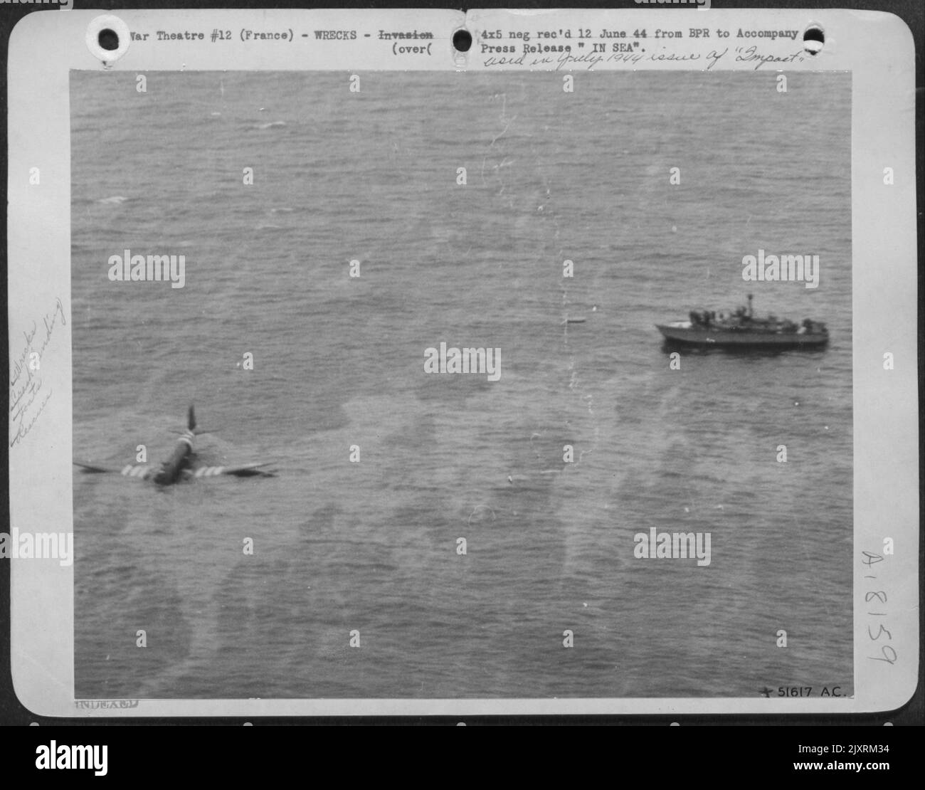 Ein Transportflugzeug der US Army 8. der Luftwaffe landet im Ozean vor der Küste Frankreichs. Eines der Schiffe der riesigen Invasionsflotte stürzte in die Bergung der Besatzung. Beachten Sie die markanten Streifen an Flügeln und Rumpf, die alle alliierten Flugzeuge mitführten Stockfoto