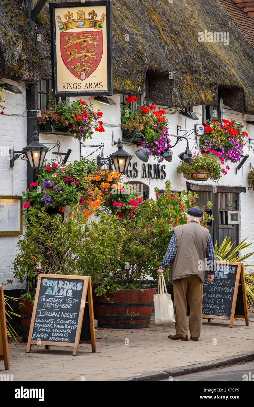 Älterer Mann, der vor einem traditionellen englischen öffentlichen Haus oder in einem Gasthaus in der dorset-Stadt wareham auf der Insel Purbeck, einem traditionellen Pub in großbritannien, steht. Stockfoto